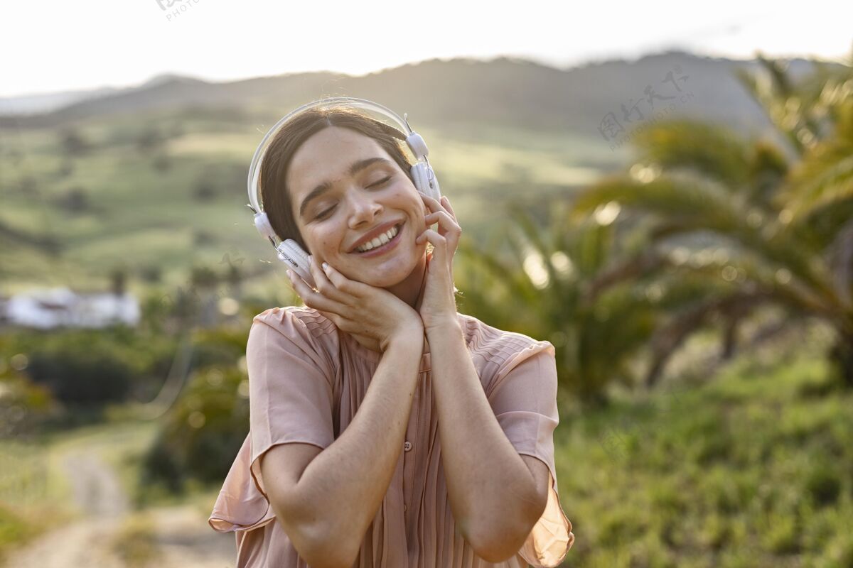 快乐中等身材的女人在听音乐放松自然女人