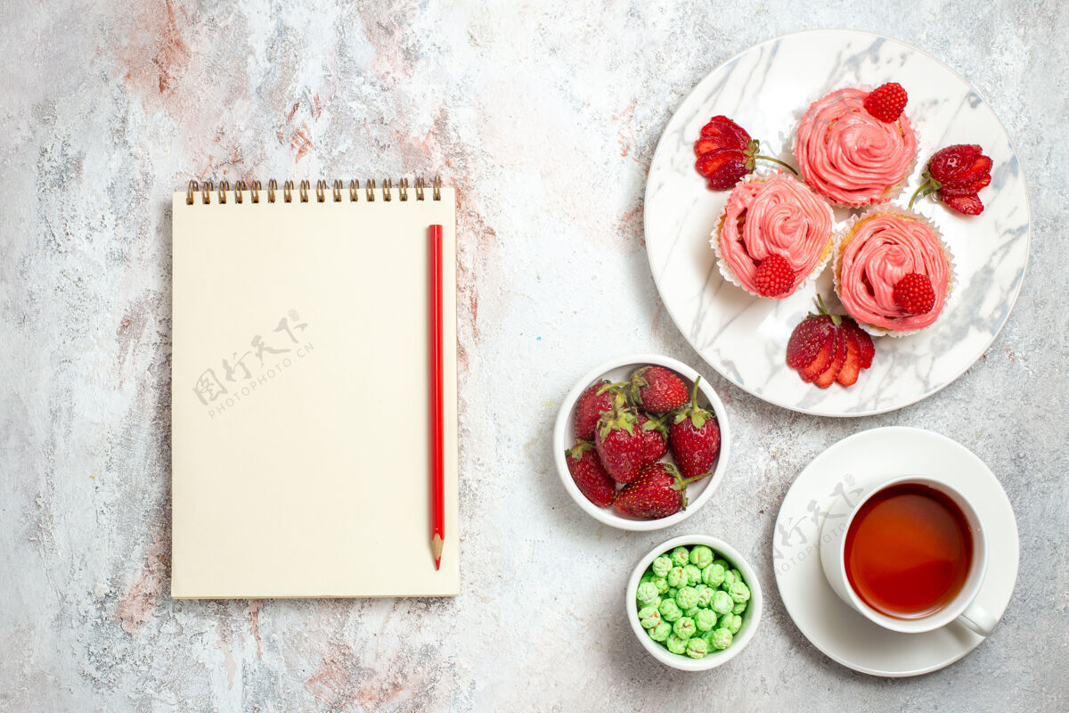 花白色表面有茶的粉色草莓蛋糕俯视图糖饼干食物