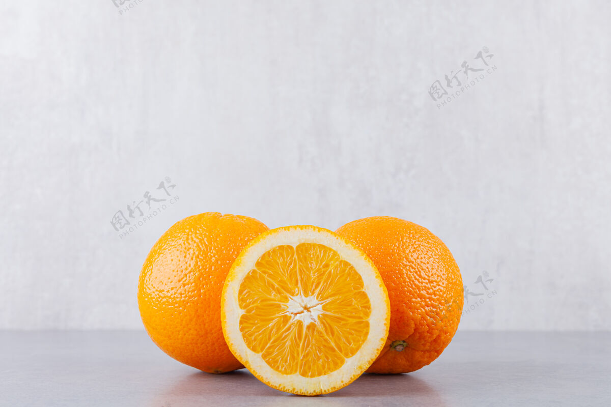 整个把整个橙子和切成片的橙子放在石桌上美味切片橙子