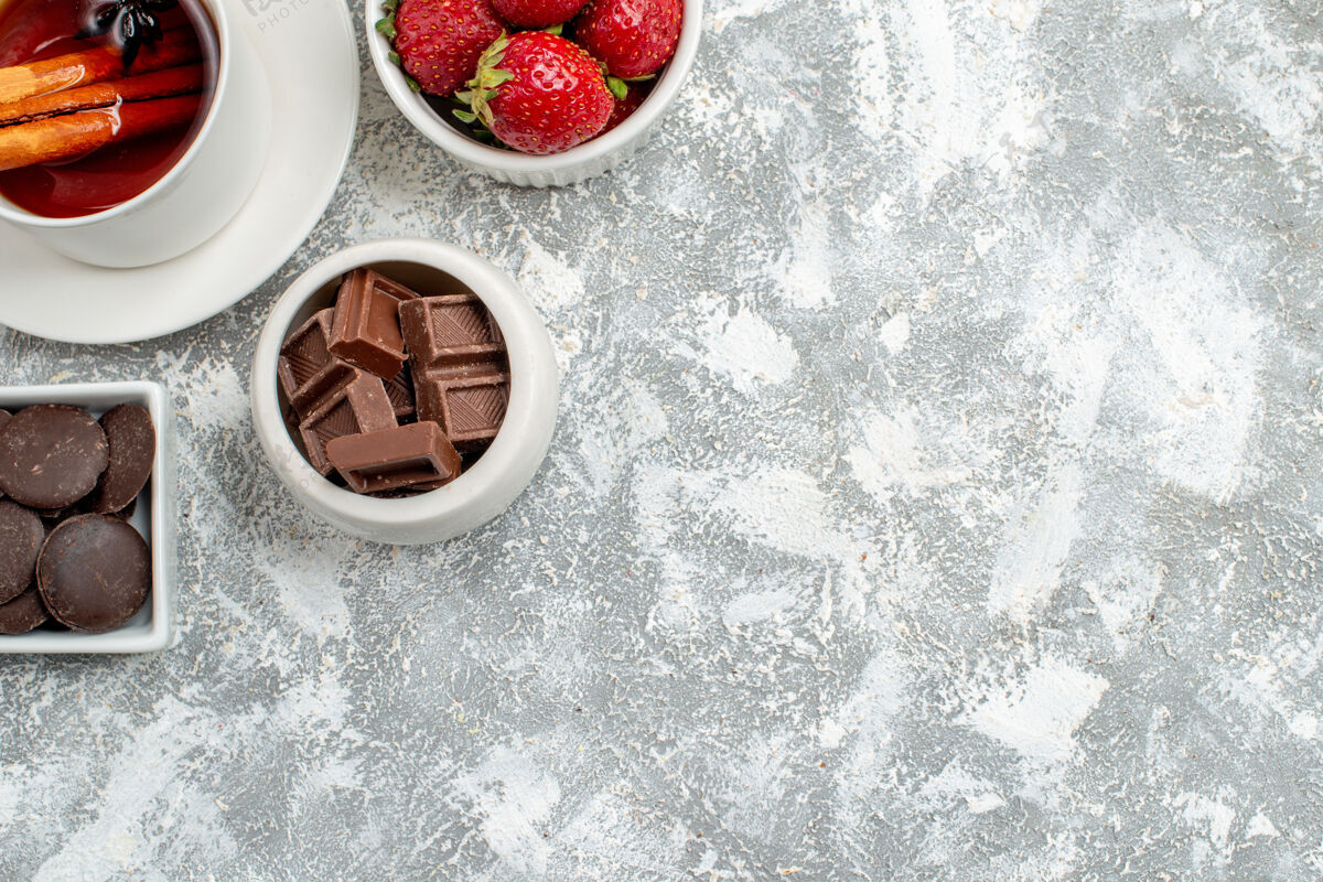 肉桂上半部分是灰白色地面左上角的草莓 巧克力和肉桂茴香籽茶碗健康水果茶