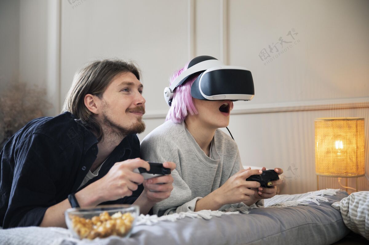 娱乐一对年轻夫妇在玩虚拟现实游戏乐趣男人在线