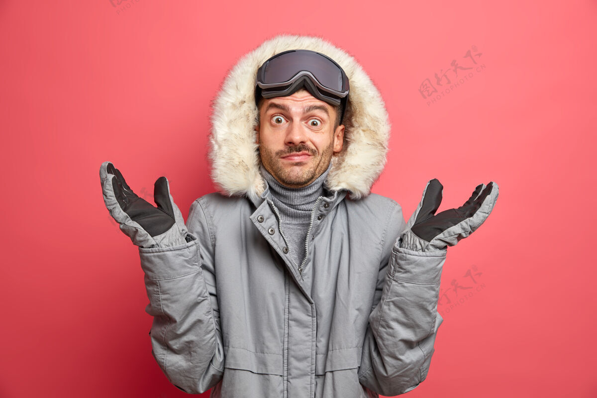 温暖困惑犹豫不决的欧洲成年男子怀疑地耸耸肩穿着冬季外套和手套在冬季滑雪人犹豫手套