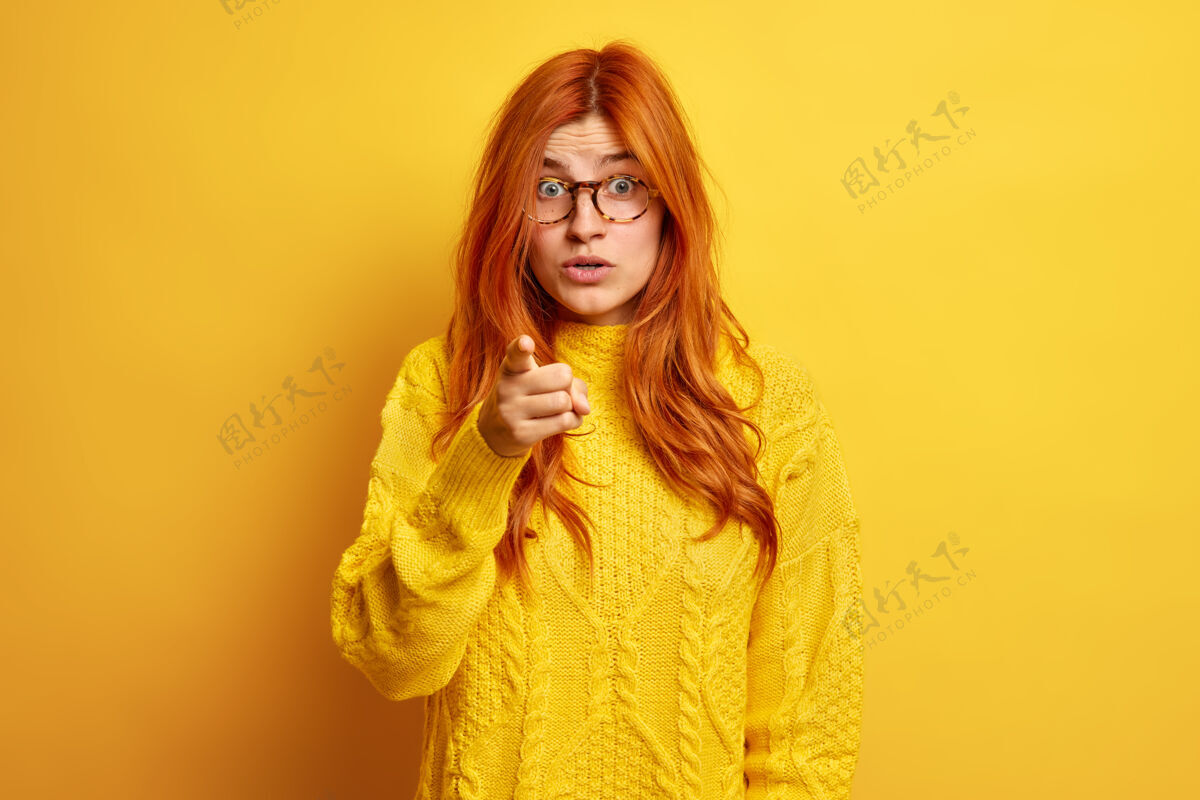 眼镜红发的欧洲女人用食指指着你 看到一些神奇的东西 戴着透明眼镜 穿着暖和的毛衣 感到很震惊眼镜手指建议