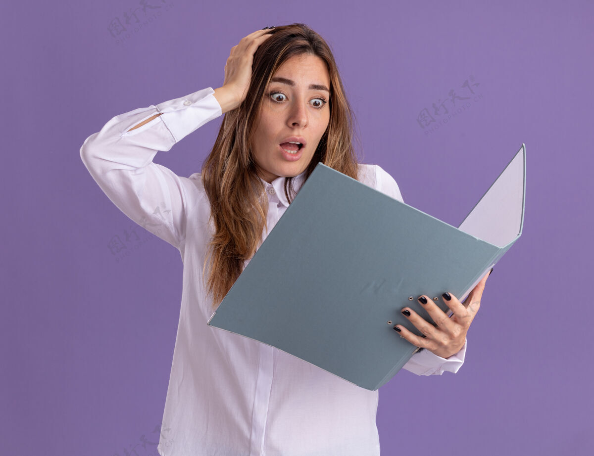 女孩焦急的年轻漂亮的白人女孩把手放在头上拿着 看着紫色的文件夹焦虑漂亮举行