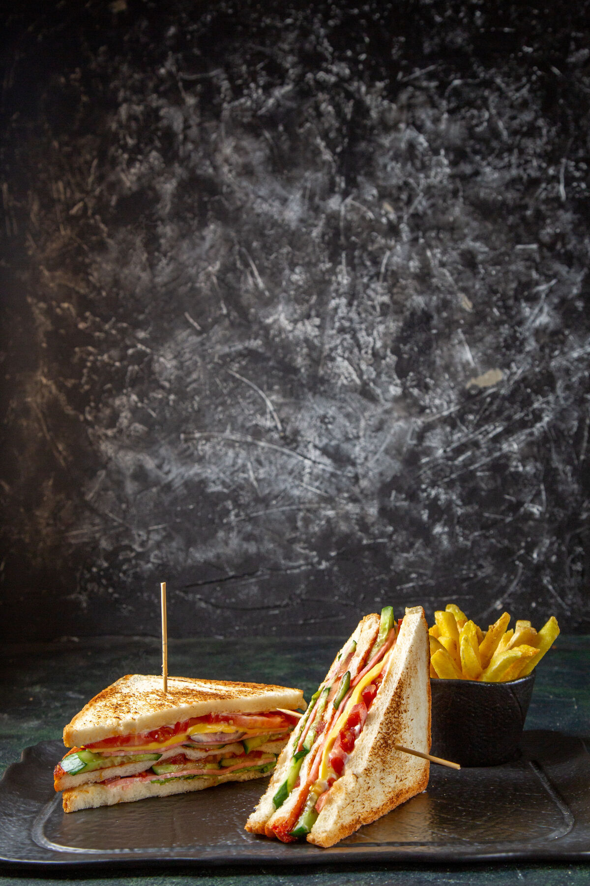 汉堡正面是美味的火腿三明治和炸薯条深色的表面烧烤法国面包