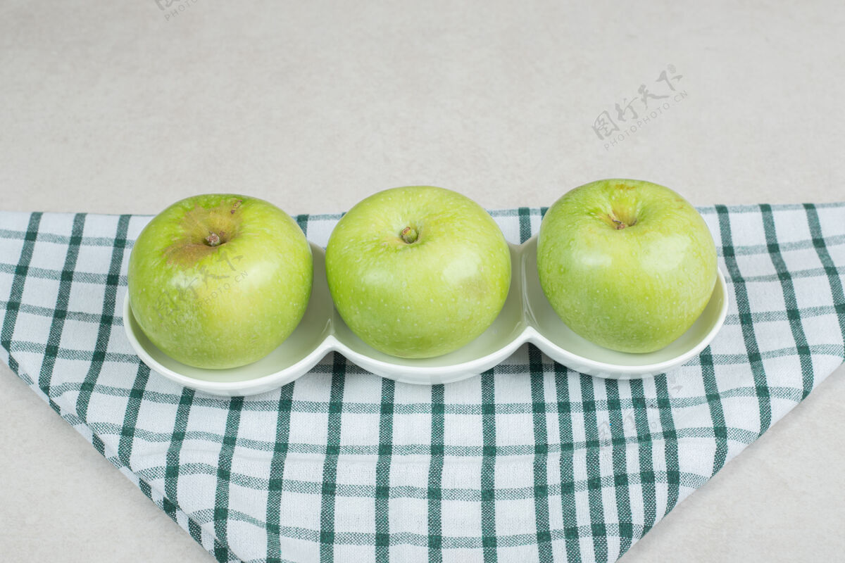 有机整个青苹果放在白板上 还有条纹桌布水果食品营养