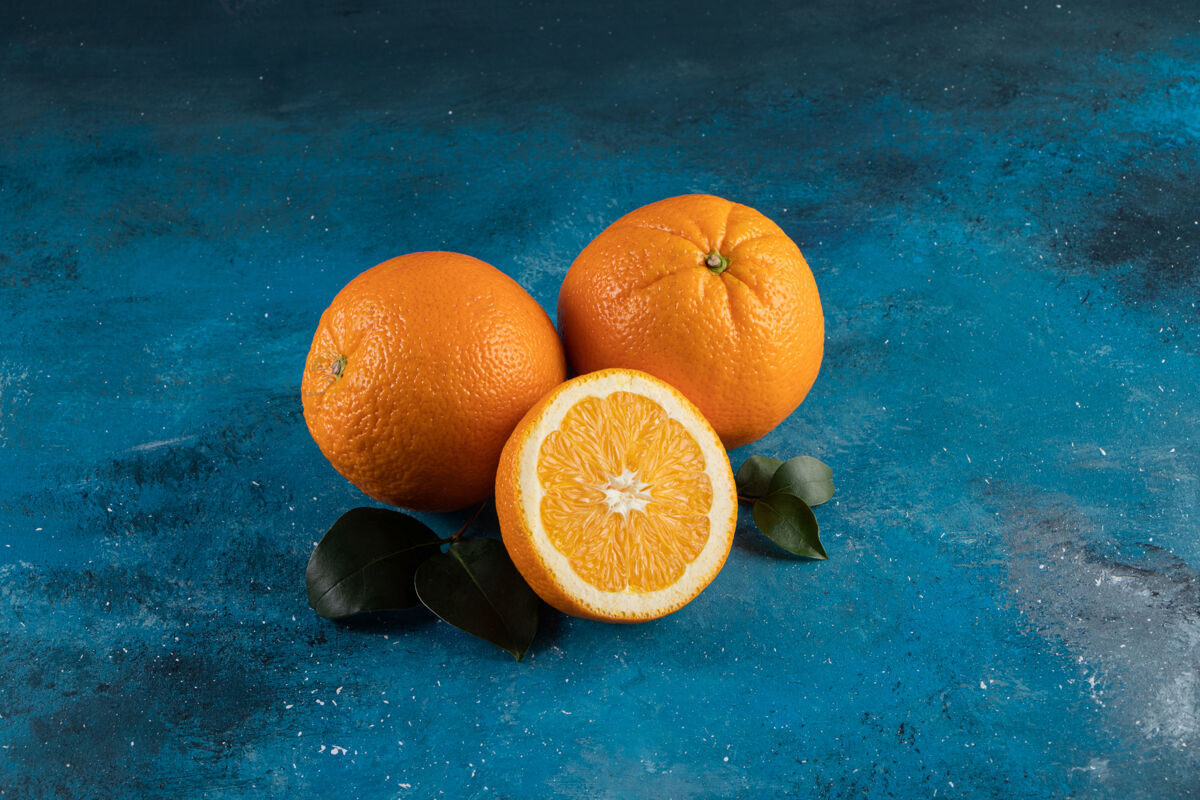 多汁一堆新鲜的橘子 在蓝色的表面上滋养膳食水果