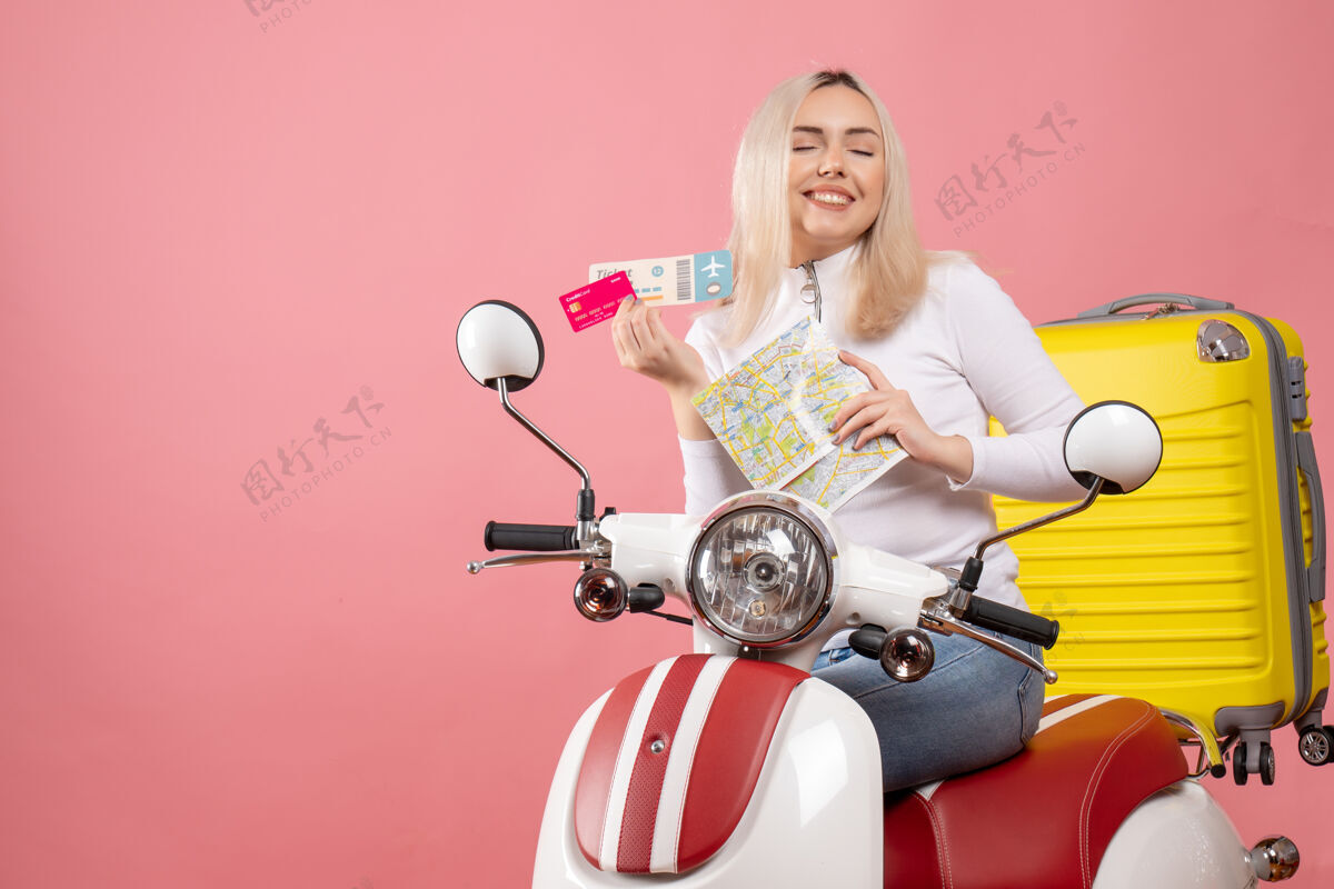 地图正面图骑着轻便摩托车的快乐小姐拿着地图票和卡片微笑前面摩托车