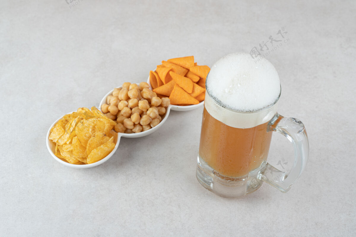 酒精小吃碗和一杯啤酒放在石头表面提神膳食玻璃杯