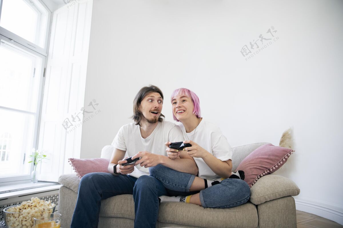 乐趣可爱的情侣在沙发上玩电子游戏视频游戏室内娱乐