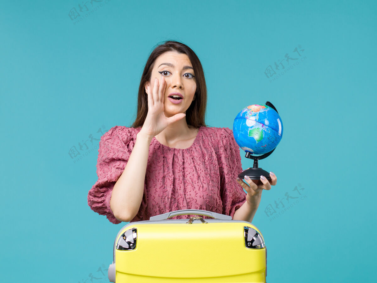 成人前景度假女手持蓝色背景上的小地球仪旅行海女旅行度假暑假小地球女人