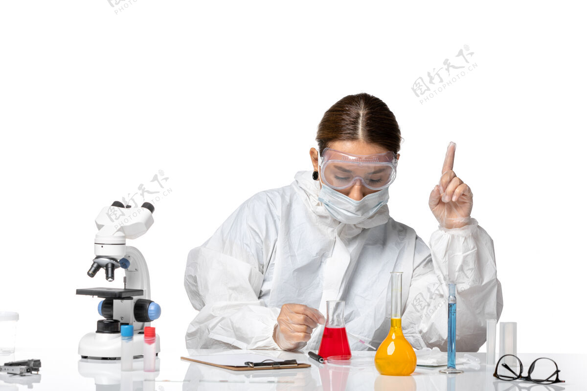 视图前视图穿着防护服 戴着口罩的女医生正在用浅白色背景的冠状病毒大流行病毒的溶液工作大流行套装人
