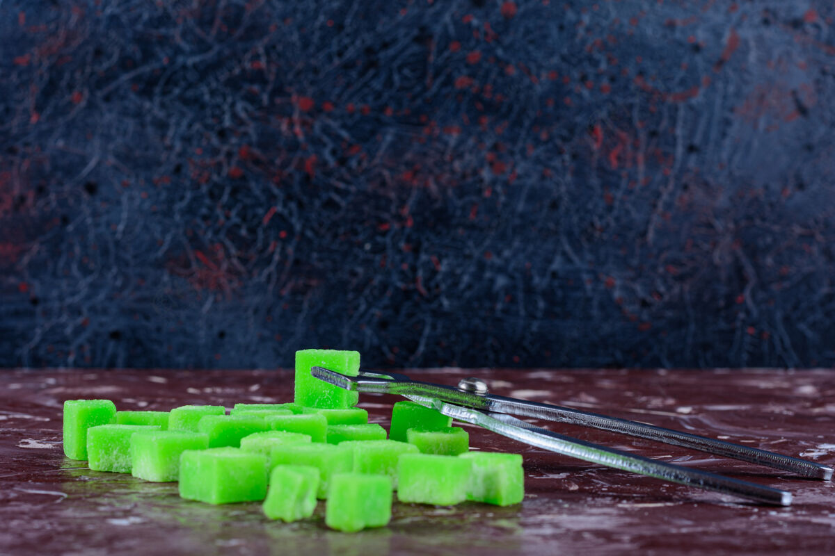 填充甜甜的绿色枕头形状的糖果在一个光明的表面堆食物团体
