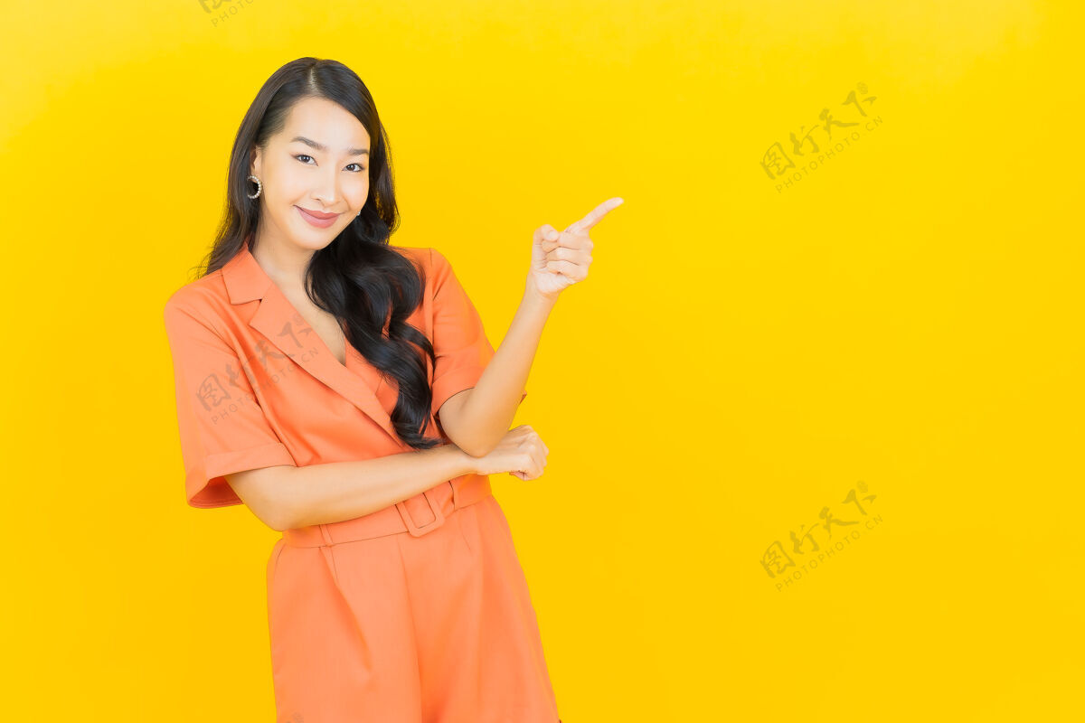 模特肖像美丽的亚洲年轻女子微笑着行动黄色时尚肖像时尚