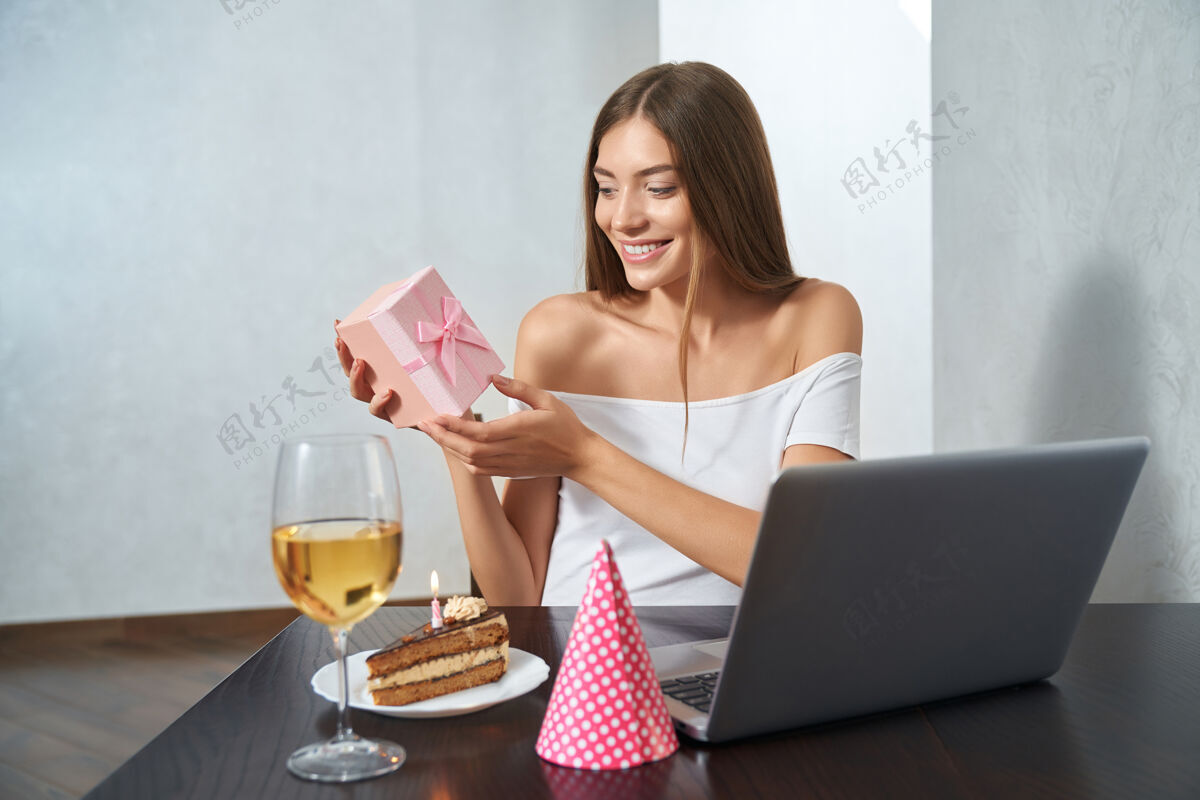 单独女人在网上庆祝时打开礼物社会距离互联网笔记本电脑