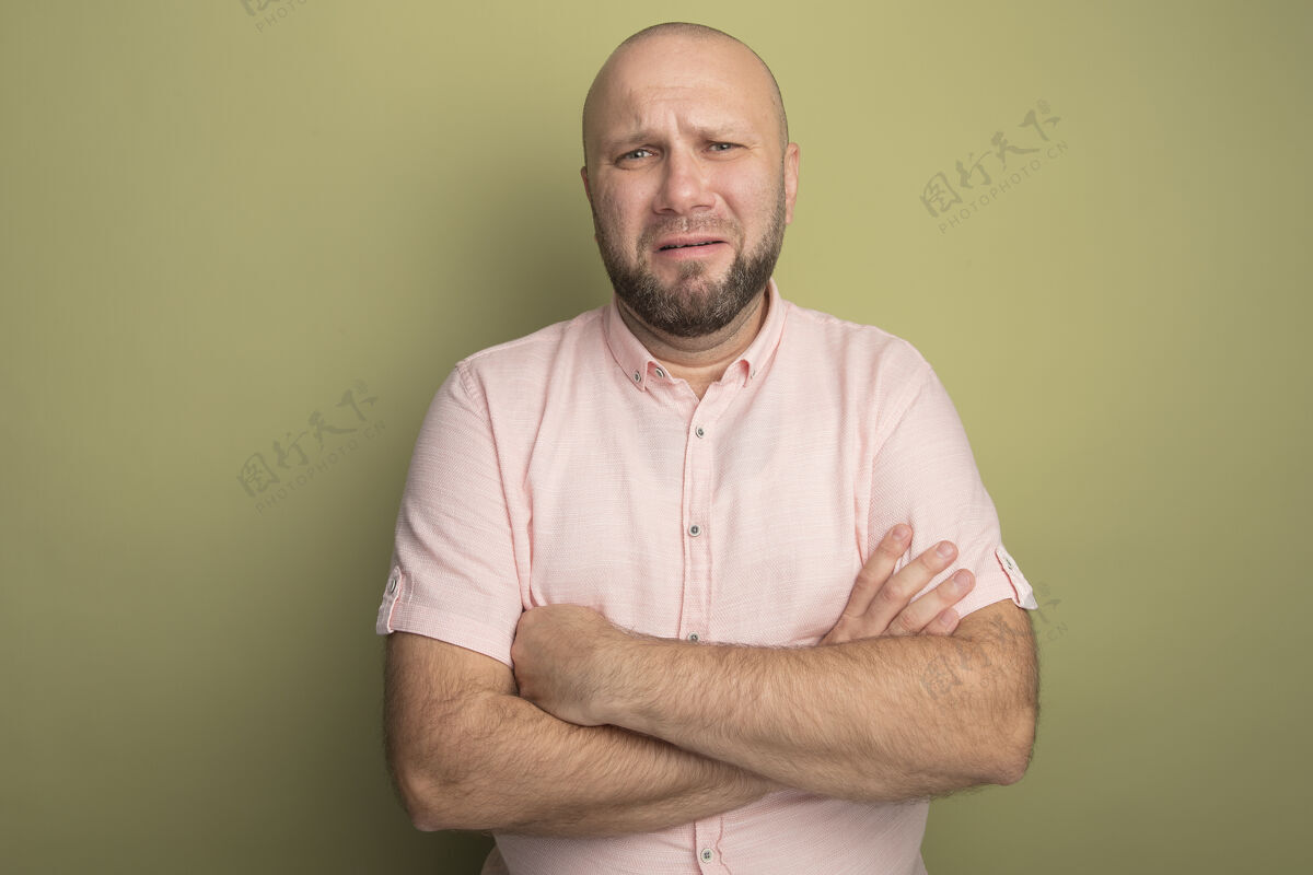 秃头悲伤的中年秃头男子穿粉红色t恤交叉双手男人悲伤交叉