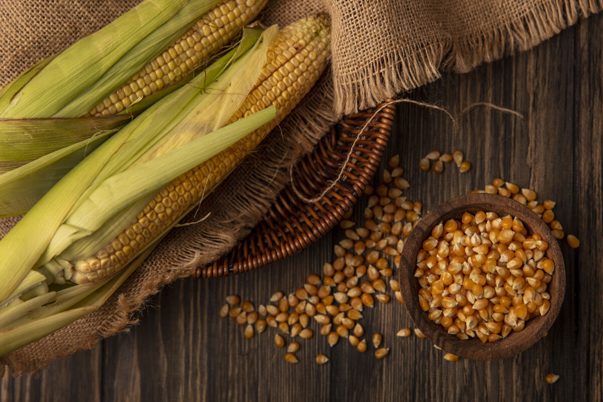 食物木碗上的有机新鲜玉米粒顶视图 木桶上的新鲜玉米粒与木桌上分离的玉米粒新鲜有机景观