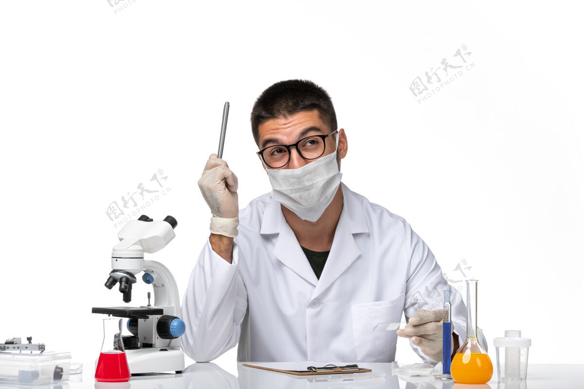 健康前视图穿着白色医疗服的男医生在一个浅白色的空间里工作和写作工作专业人