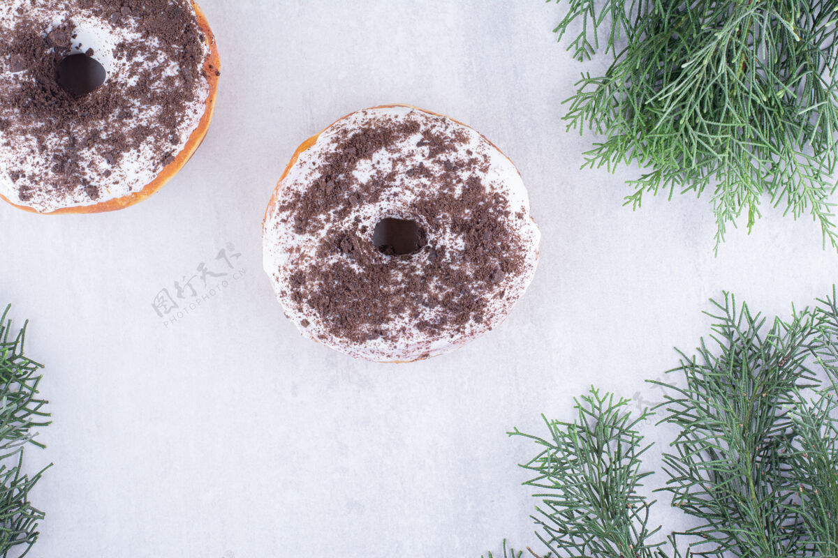 甜点甜甜圈展示在白色的松叶中小吃烘焙树枝