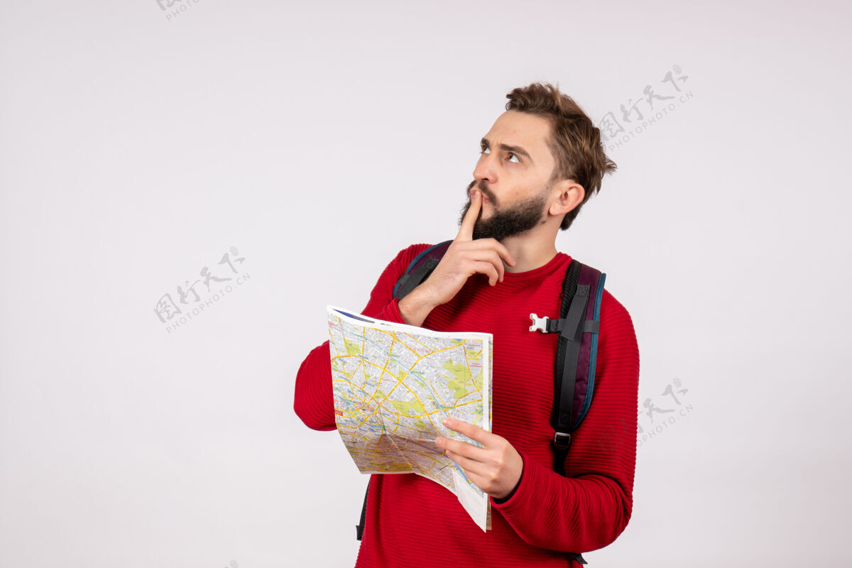 城市正面图年轻男性游客背着背包探索地图思考白墙飞机城市度假情感人文旅游思考风景背包