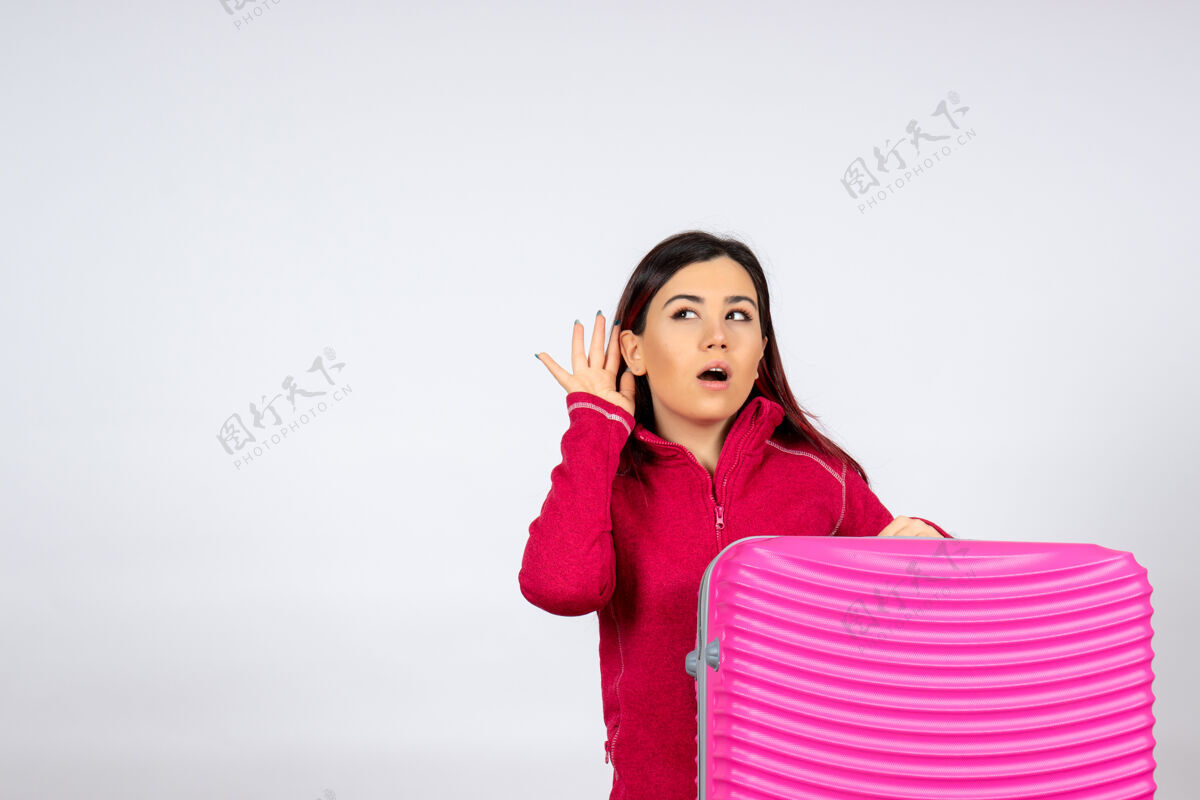 风景正面图年轻女性带着粉色的包听着白墙上的情感度假女性色彩之旅航程飞行度假情感年轻的女性