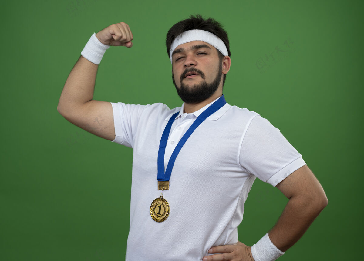 头带自信的年轻人戴着头带和腕带 带着奖牌 在绿茵场上显示出强烈的姿态穿奖牌腕带