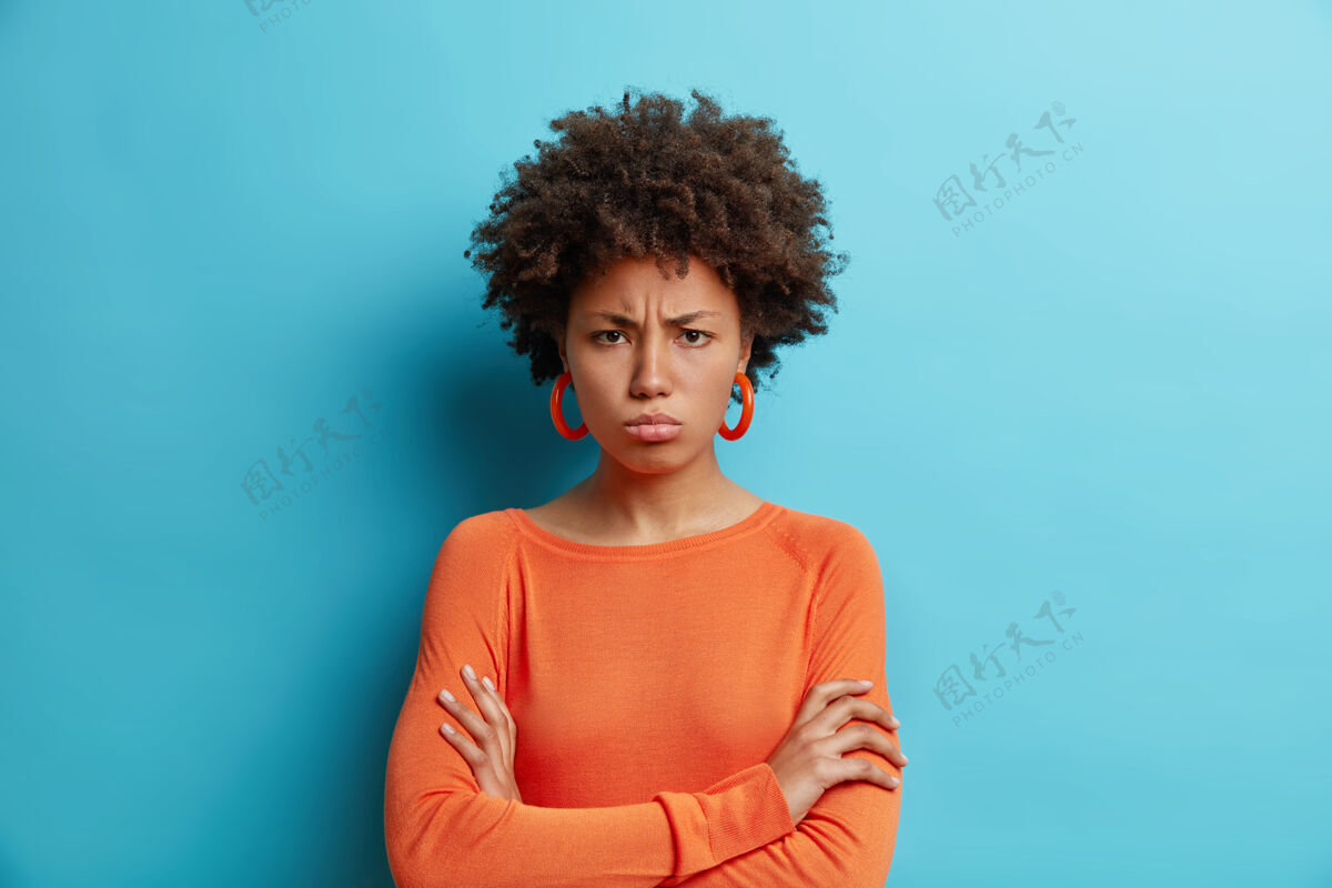 非洲裔横拍的黑皮肤被冒犯的非洲头发女人双臂交叉有攻击性的表情不高兴一个不安