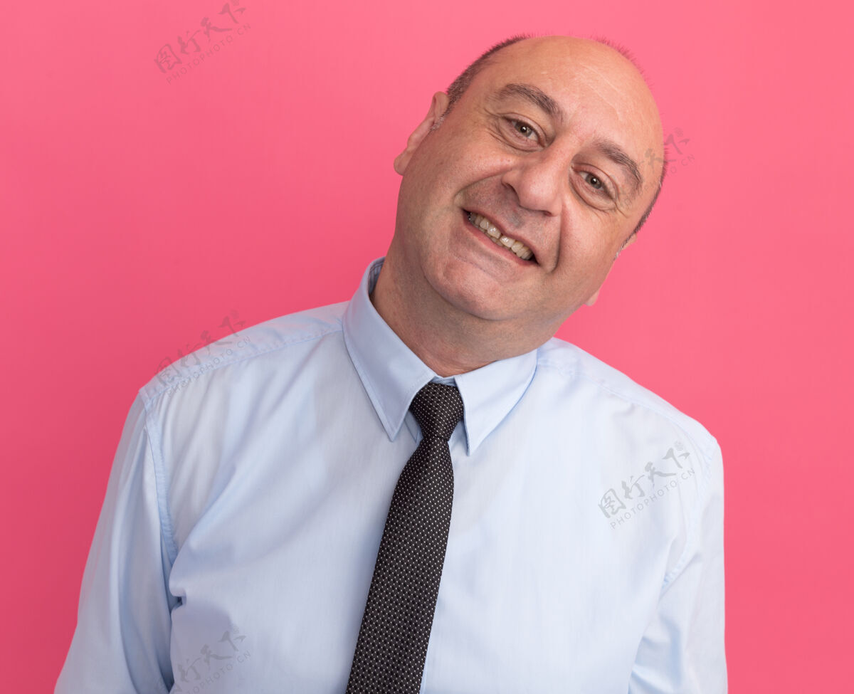 倾斜一个中年男人穿着白色t恤 打着领带 隔离在粉红色的墙上中年领带男人