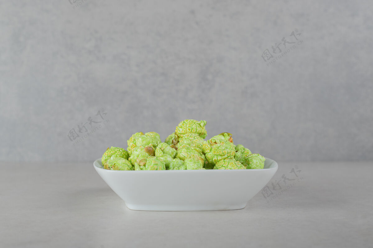 美味大理石背景上的绿色蜜饯爆米花拼盘背景糖风味