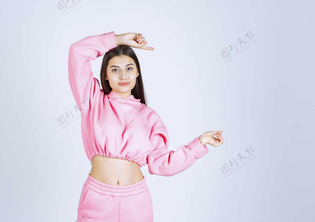 人穿着粉色睡衣的女孩摆出快乐诱人的姿势满意姿势乐趣