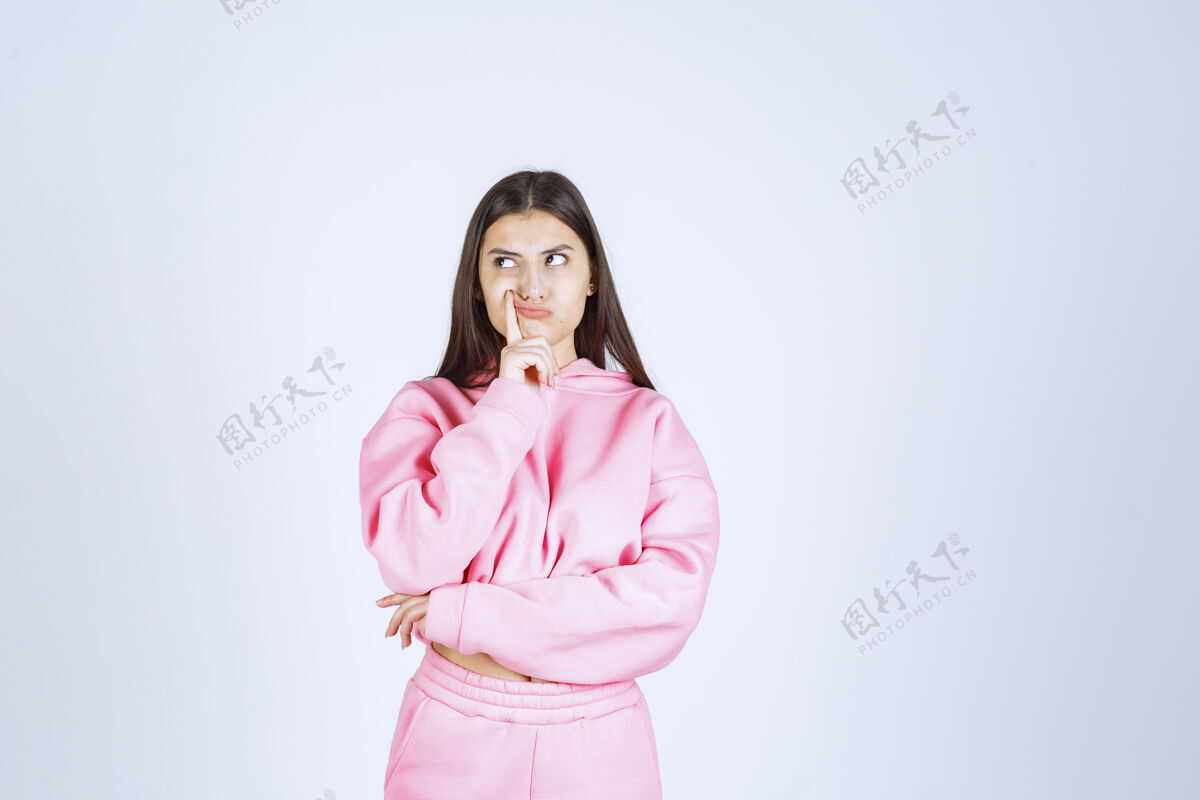 人类穿粉红色睡衣的女孩看起来既困惑又怀疑没有经验姿势成人