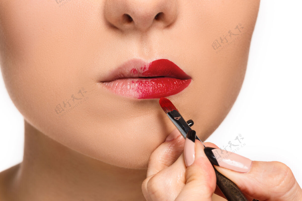 手美丽的女性唇妆与刷白化妆师的工作过程嘴唇制作面部