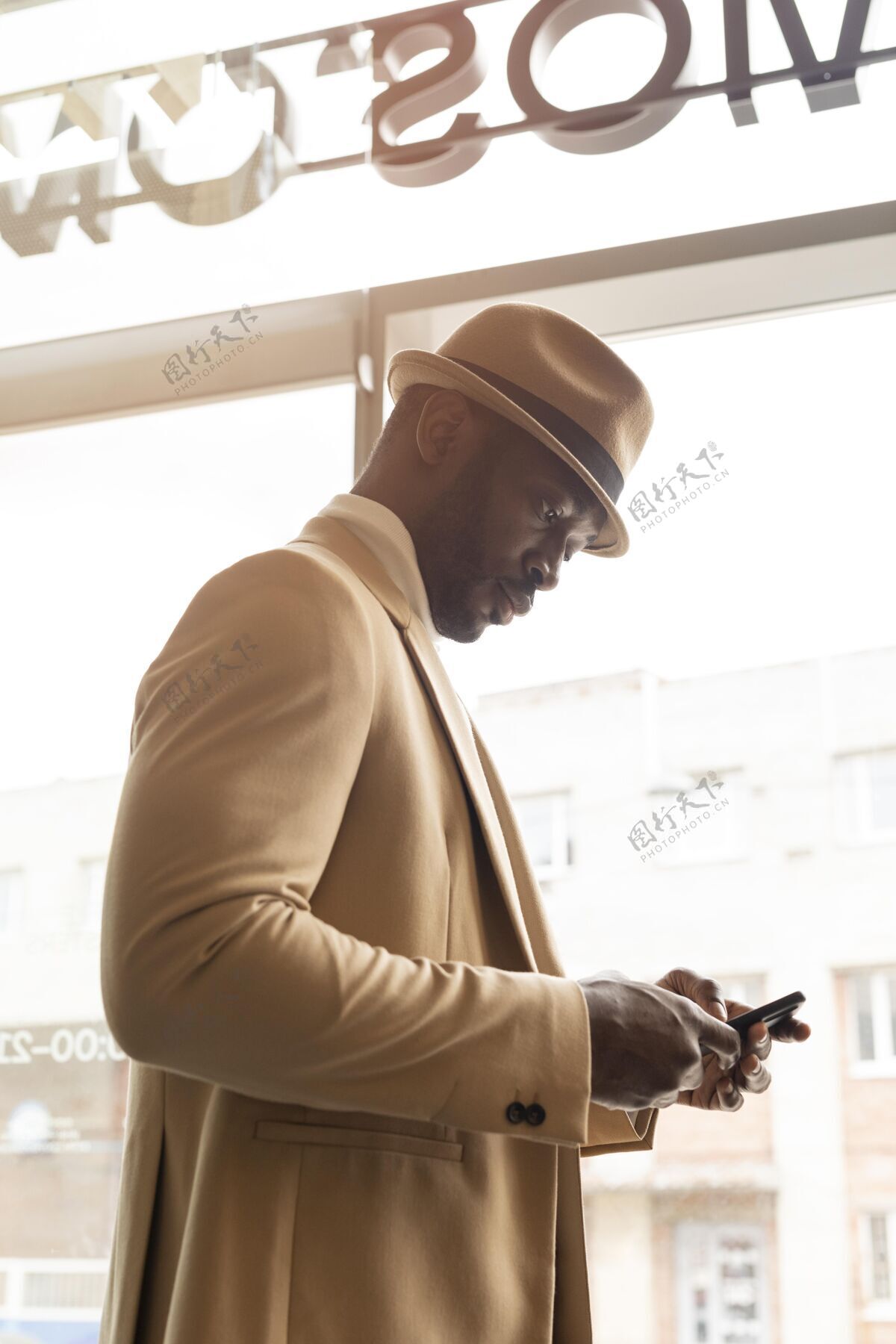 室内穿米色西装的现代男人手机自信男士