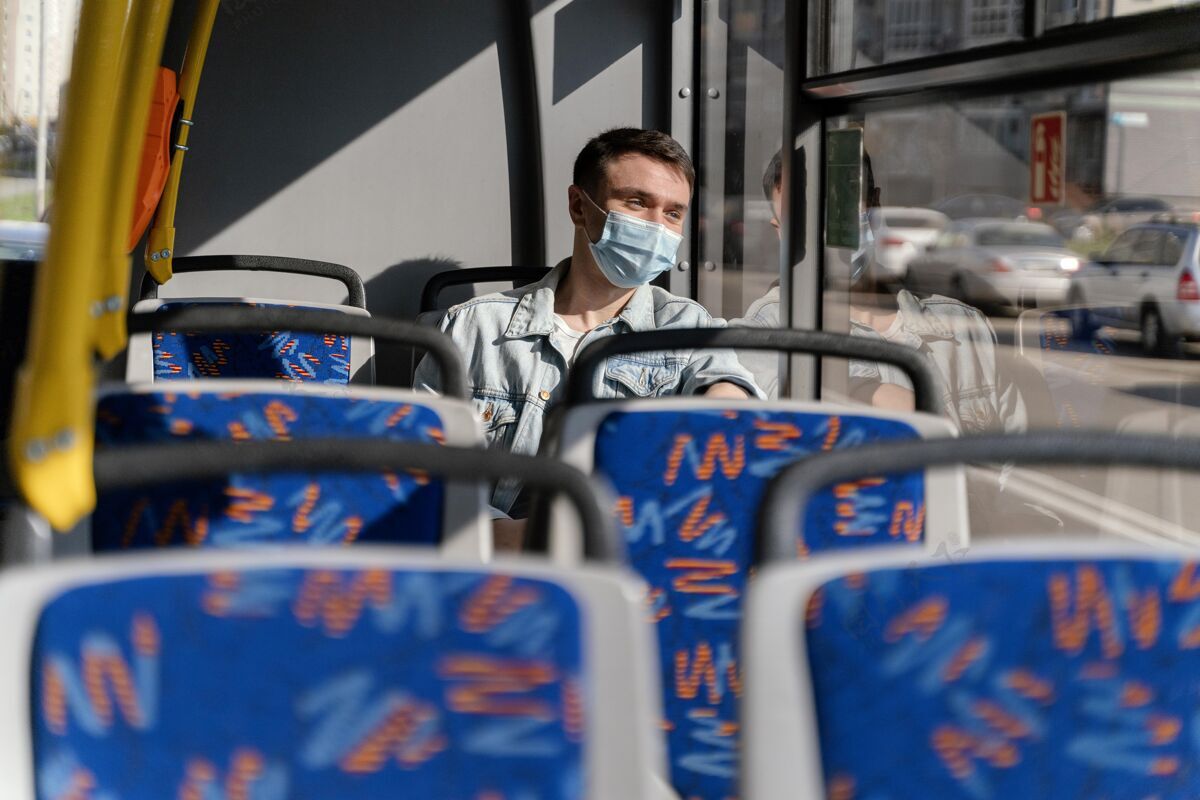 城市年轻人戴着口罩坐公交车病毒公共汽车乘客