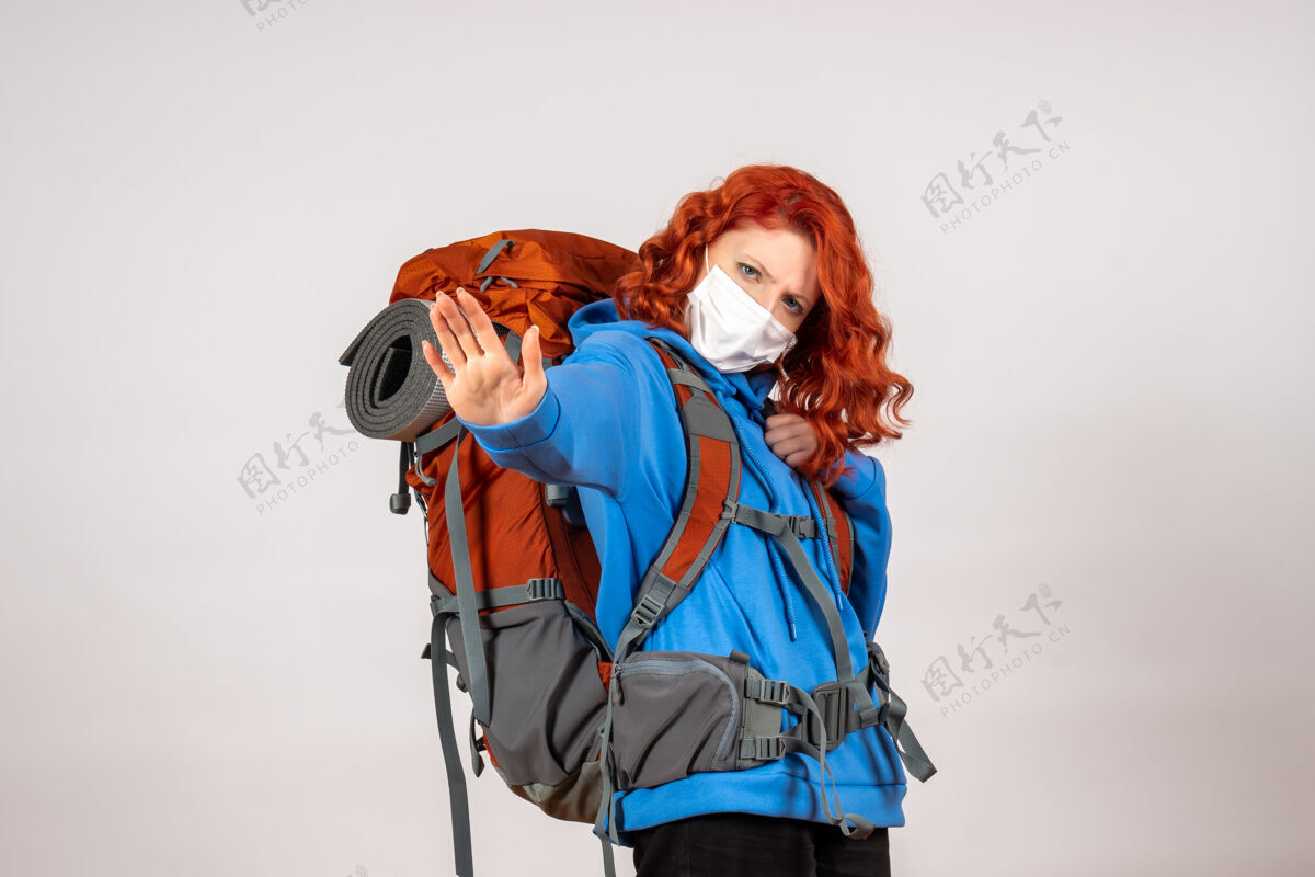 女人正面图女游客带着背包 戴着面具上山旅游猎人人年轻
