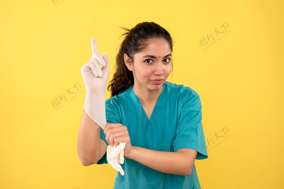 乳胶正面图：女医生戴着乳胶手套 手指朝上指着成人年轻
