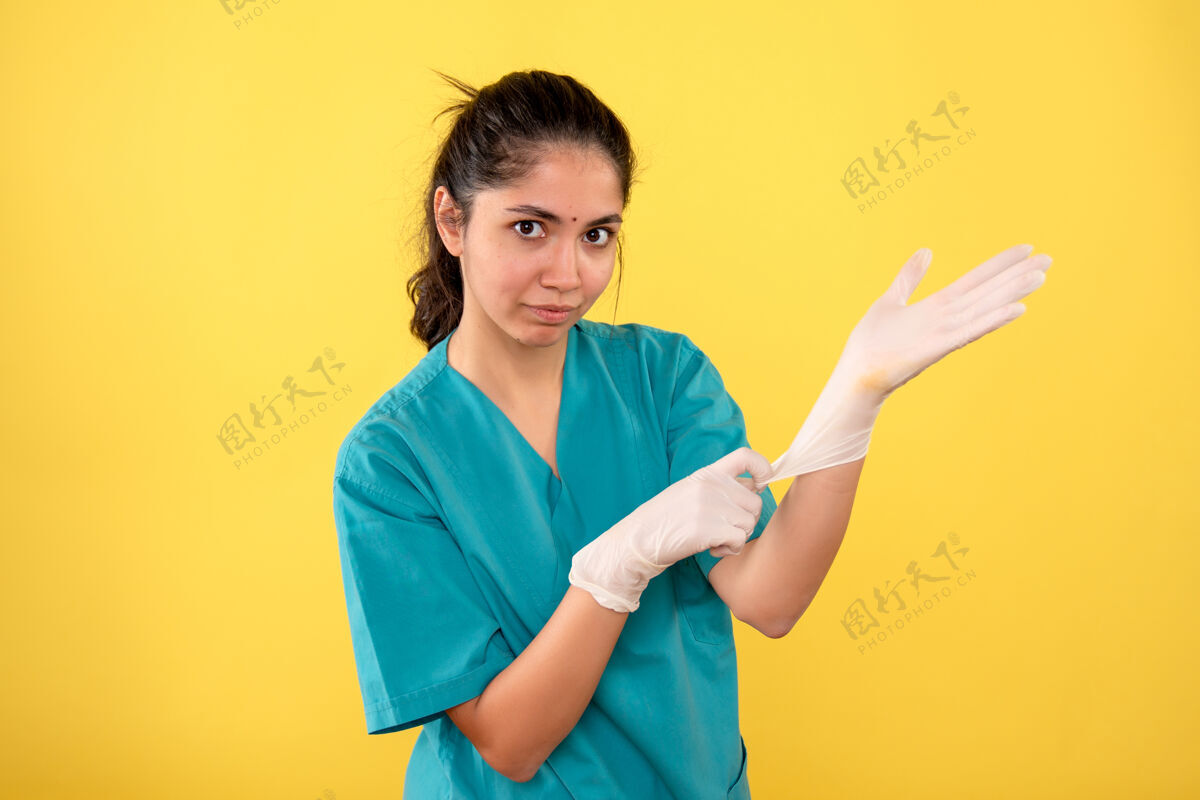 自信正面图女医生戴着乳胶手套站着年轻肖像女人