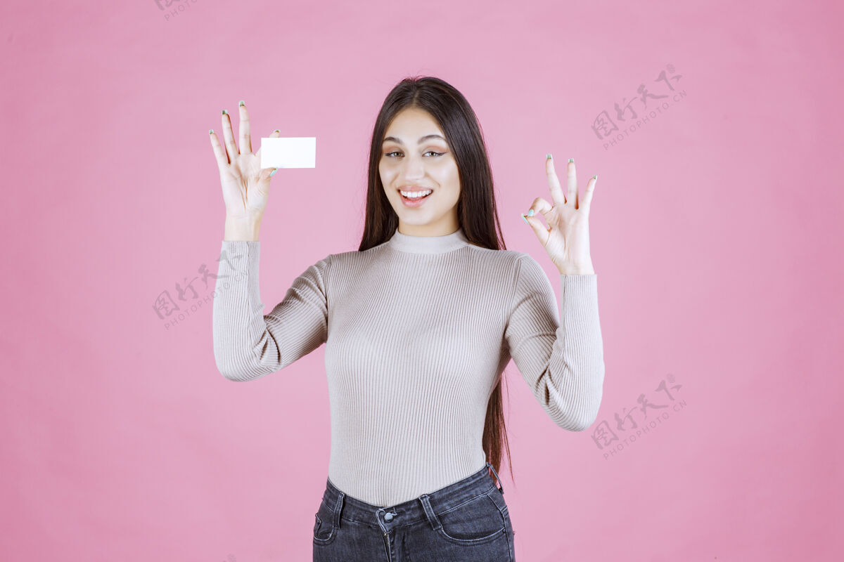 合同穿灰色毛衣的女孩在展示她的新名片制作好牌晋升女性伴侣
