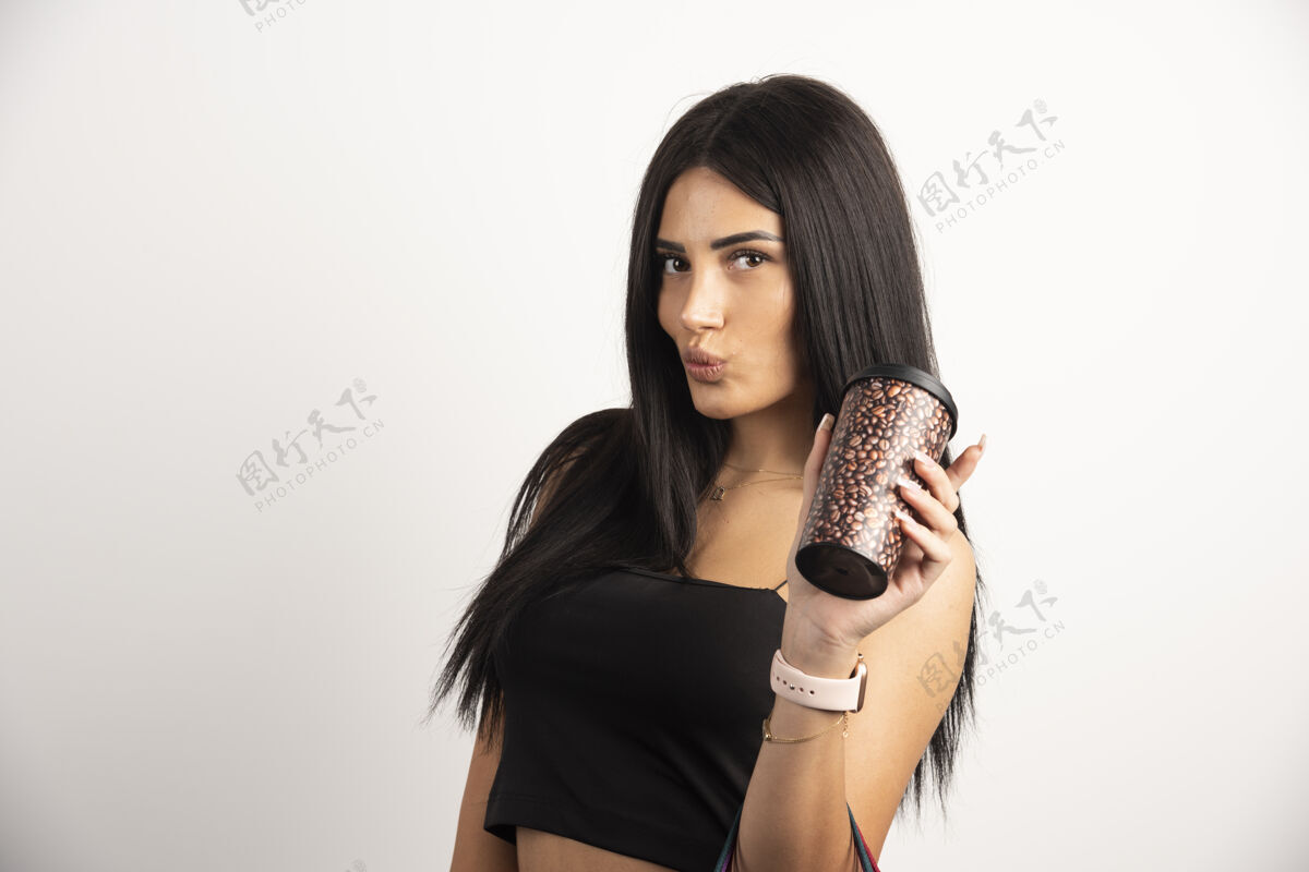 人类米色背景上拿着咖啡杯的女人的肖像高质量的照片黑发女孩人