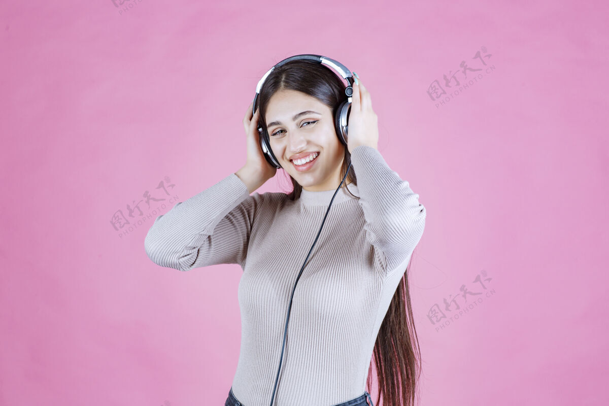迪斯科戴着耳机的女孩听着音乐 感觉很开心微笑单身轨道