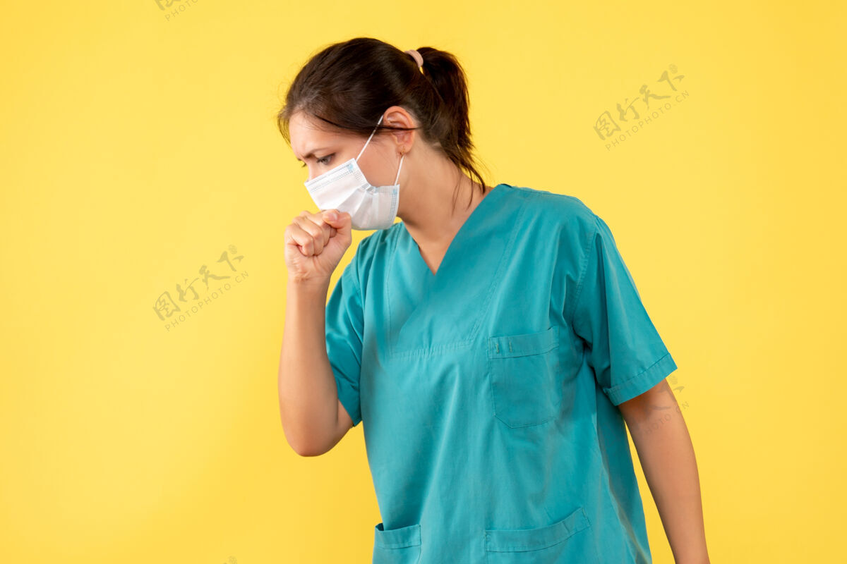 面具正面图：穿着医用衬衫 戴着消毒口罩的女医生在黄色背景下咳嗽黄色健康成人