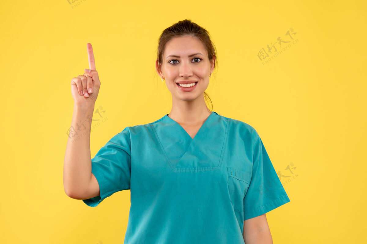 成人前视图黄色背景上穿着医用衬衫的女医生健康微笑视图
