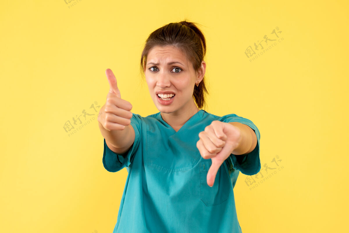 成人前视图黄色背景上穿着医用衬衫的女医生肖像人视图
