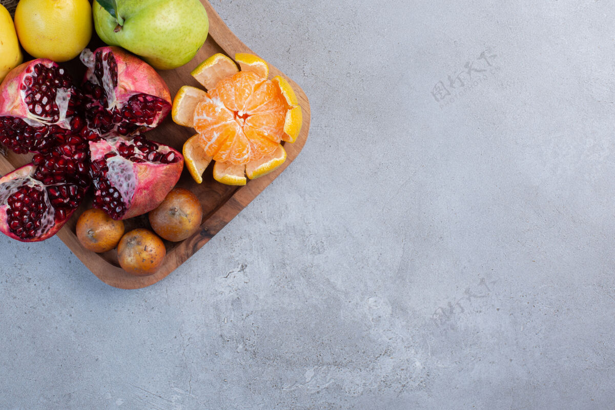 美味碎石榴 去皮的橘子 整片的木瓜和梨放在大理石背景的布上营养新鲜梨