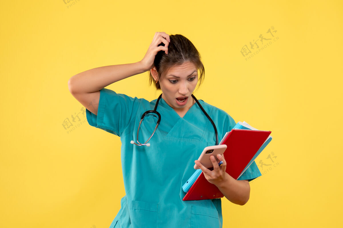 医生前视图穿着医疗衬衫的女医生拿着黄色背景上的分析和电话健康前面视图