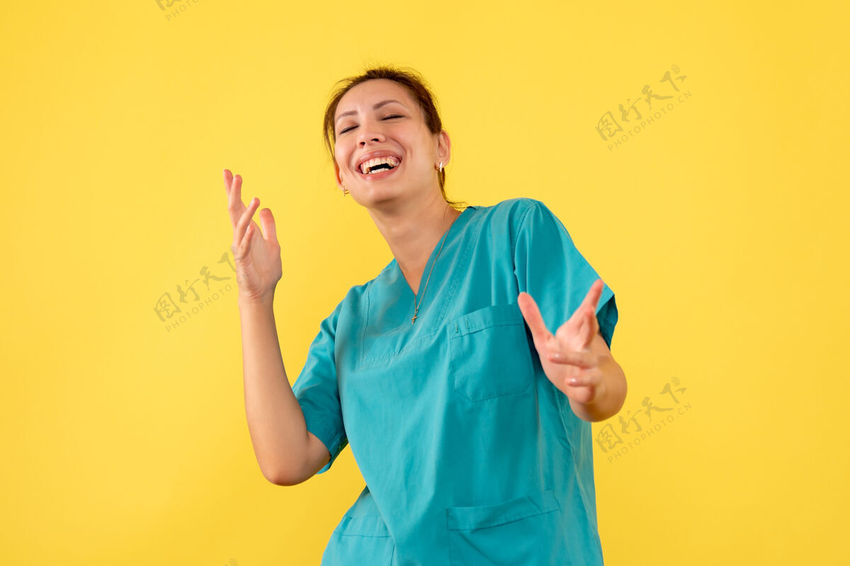 微笑正面图黄色背景下穿着医用衬衫的女医生在笑前面成人人
