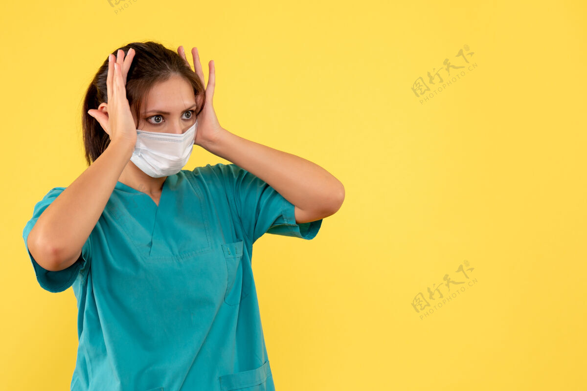 人前视图黄色背景上穿着医用衬衫和面罩的女医生脸成人医疗