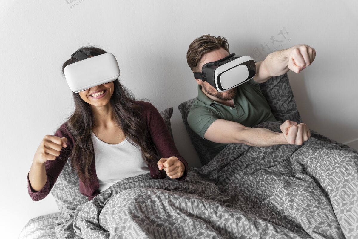 女人笑脸女人和男人在床上使用虚拟现实耳机家庭虚拟现实增强现实