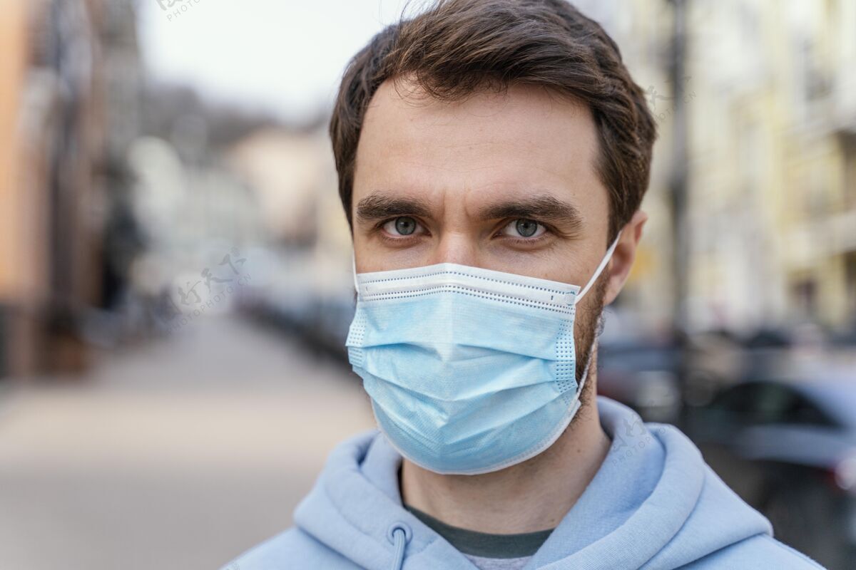 面具城市里戴着医用口罩的男人的正视图休闲享受男人