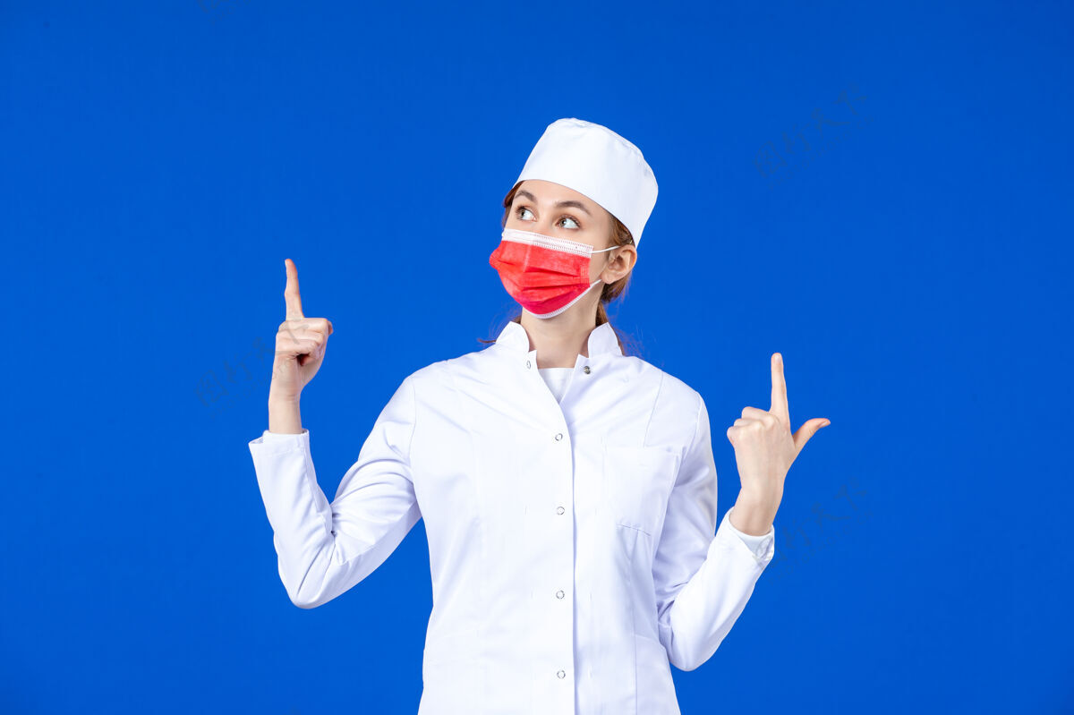 防护正面图身着医疗服的年轻护士 蓝色墙上戴着红色防护面具红色正面人员
